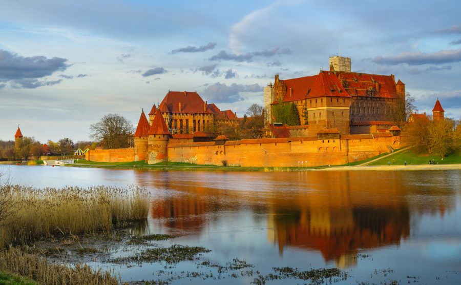 zamek Malbork w odbiciu wody, gdzie jechać w październiku w Polsce
