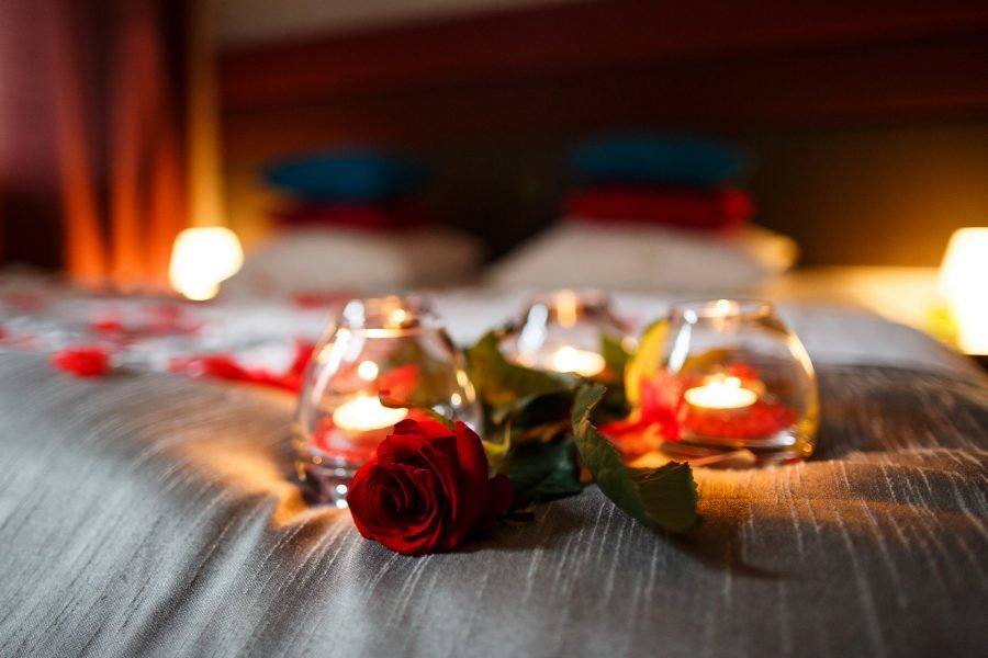 walentynki w hotelu z różą i świecami na łóżku