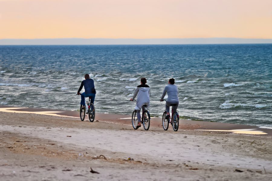 rodzina jadąca rowerami brzegiem bałtyku