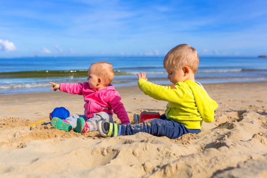 małe dzieci siedzą na plaży nad bałtykiem
